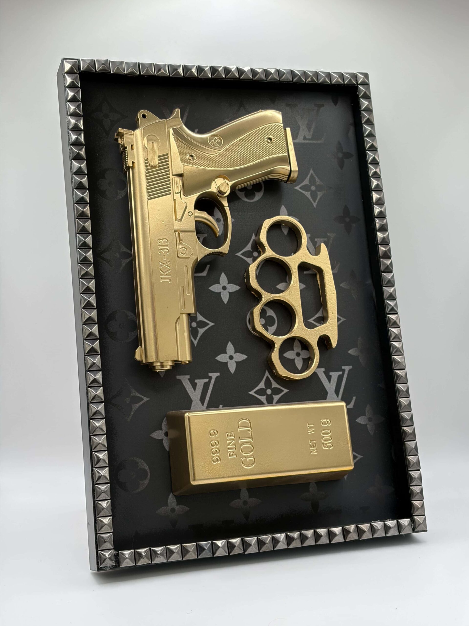 Quadro d'arredamento moderno con icone 3D in oro, pistola, lingotto e tirapugni su sfondo monogram luxury.
