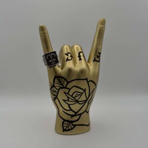 Mano porta anelli design tattoo oro stile rock on con tatuaggi neri
